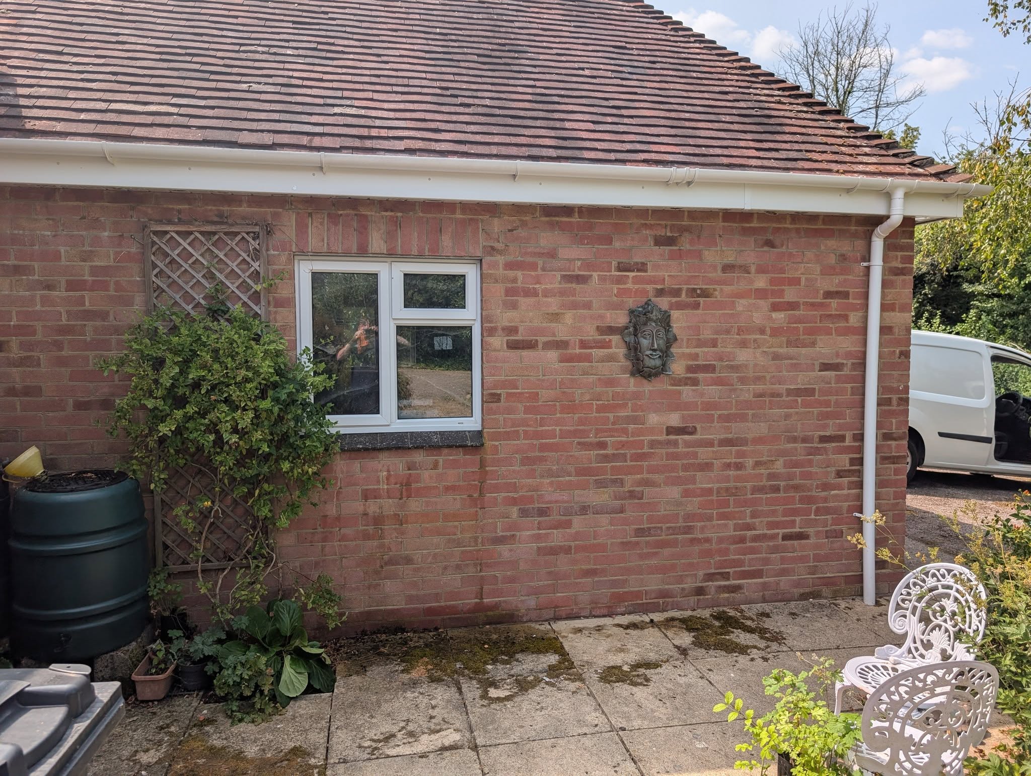 A red-brick bungalow with a cleaned window over the patio