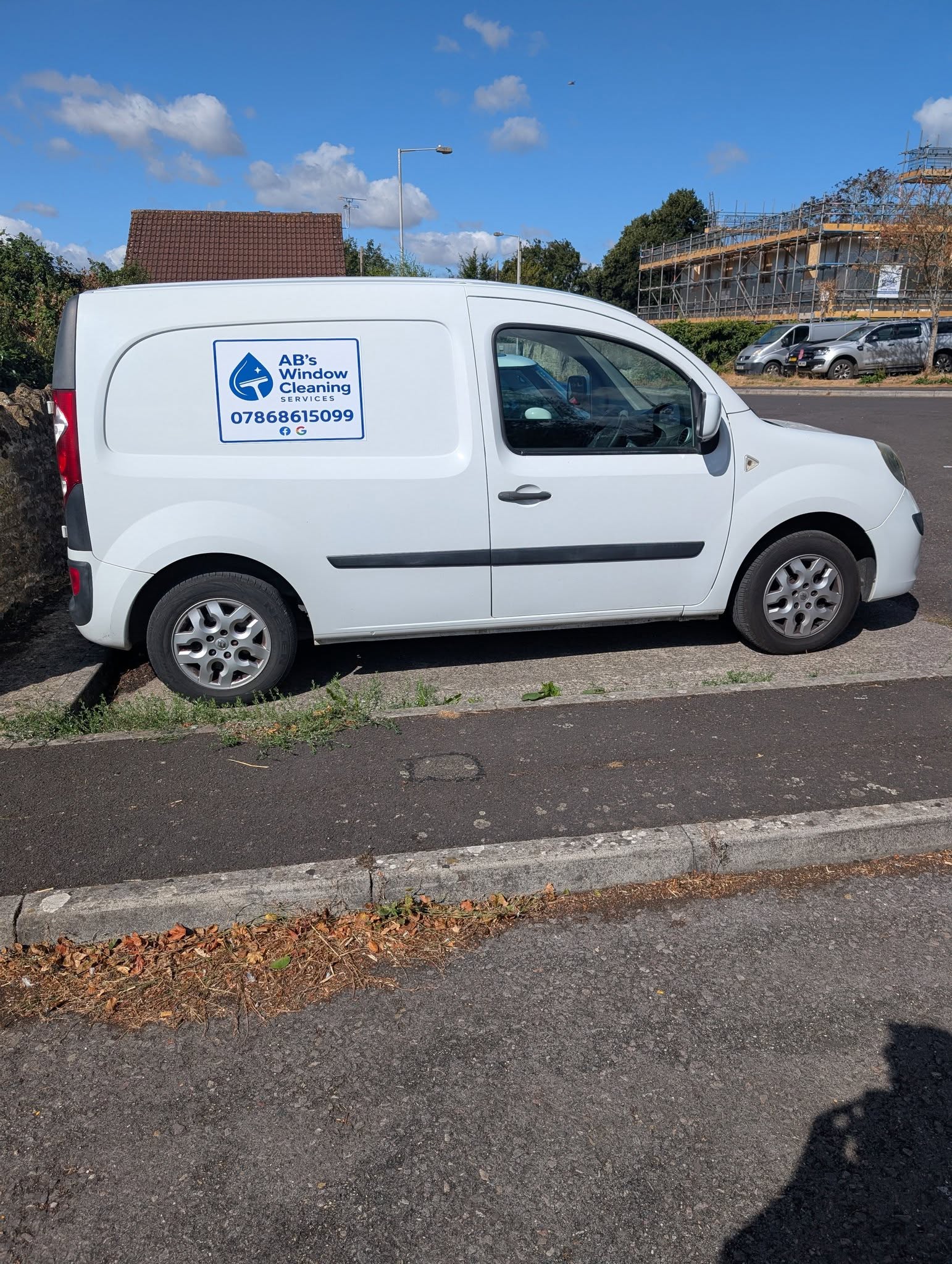 The white AB's Window Cleaning van with its logo panel and phone number