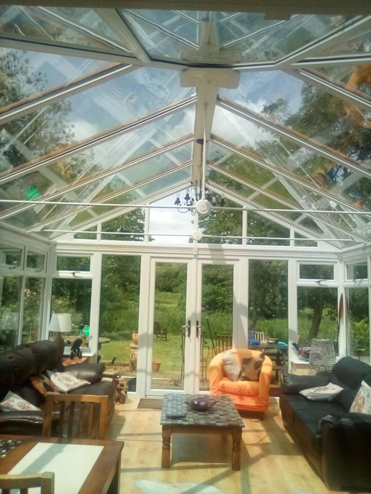 Inside a conservatory, the glass roof and walls clean and bright